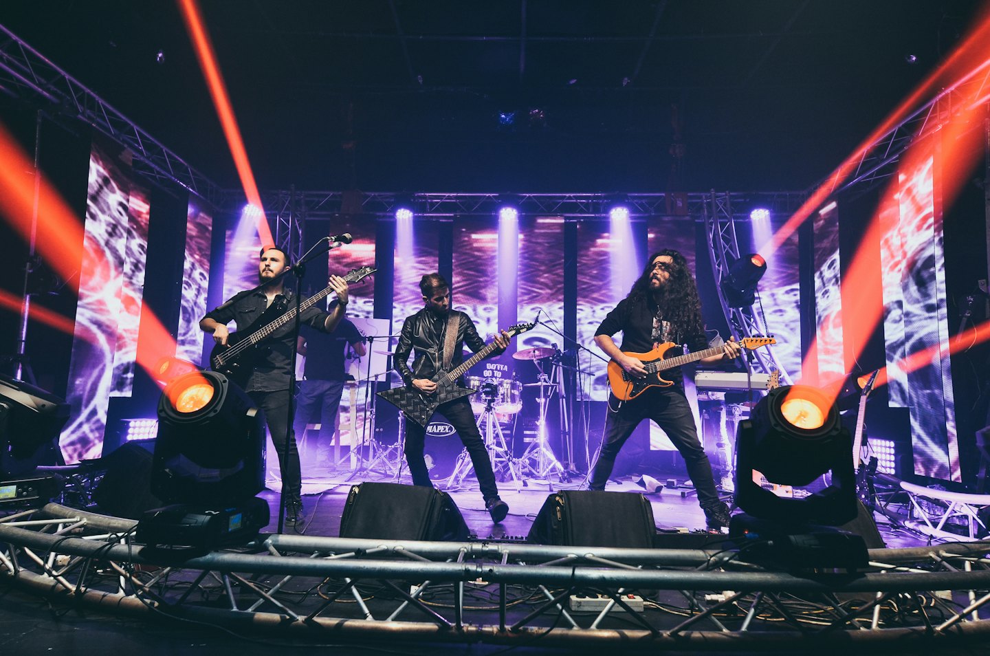 Band members playing instruments on stage during a concert.